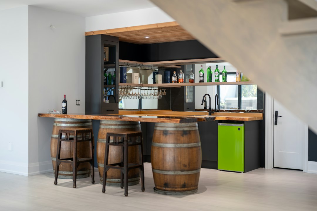 Home bar with a live edge wood counter and wooden barrel stools
